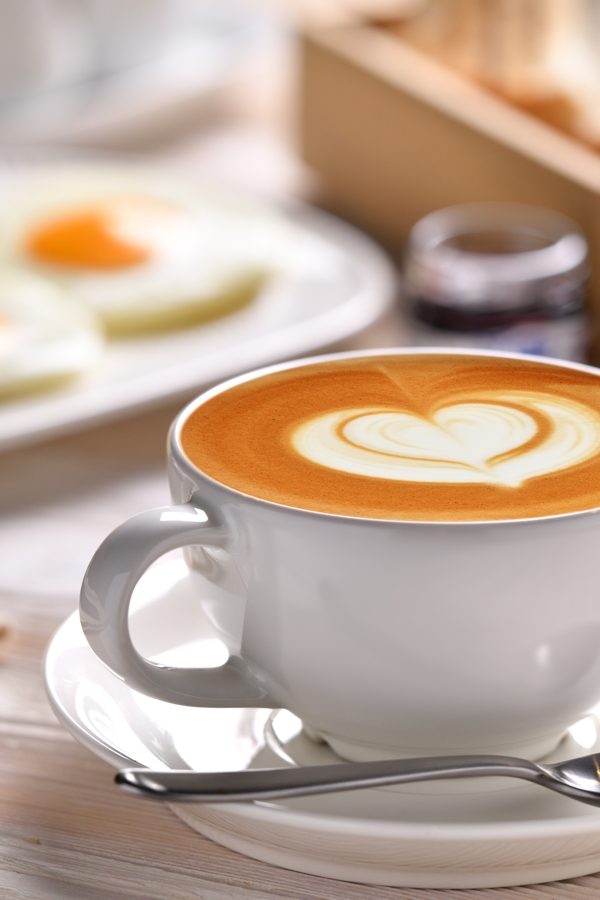Cup of coffee latte with breakfast on wooden table